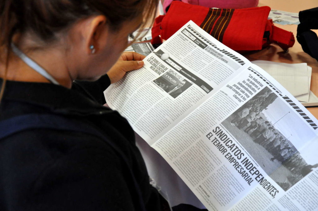 Fotografía de una mujer leyendo un periódico